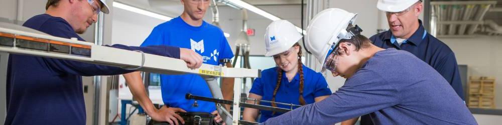 A group of students and instructors in hard hats